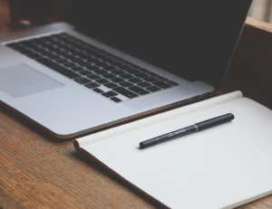 zbliżenie na notes, długopis i laptop