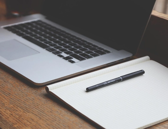 zbliżenie na notes, długopis i laptop